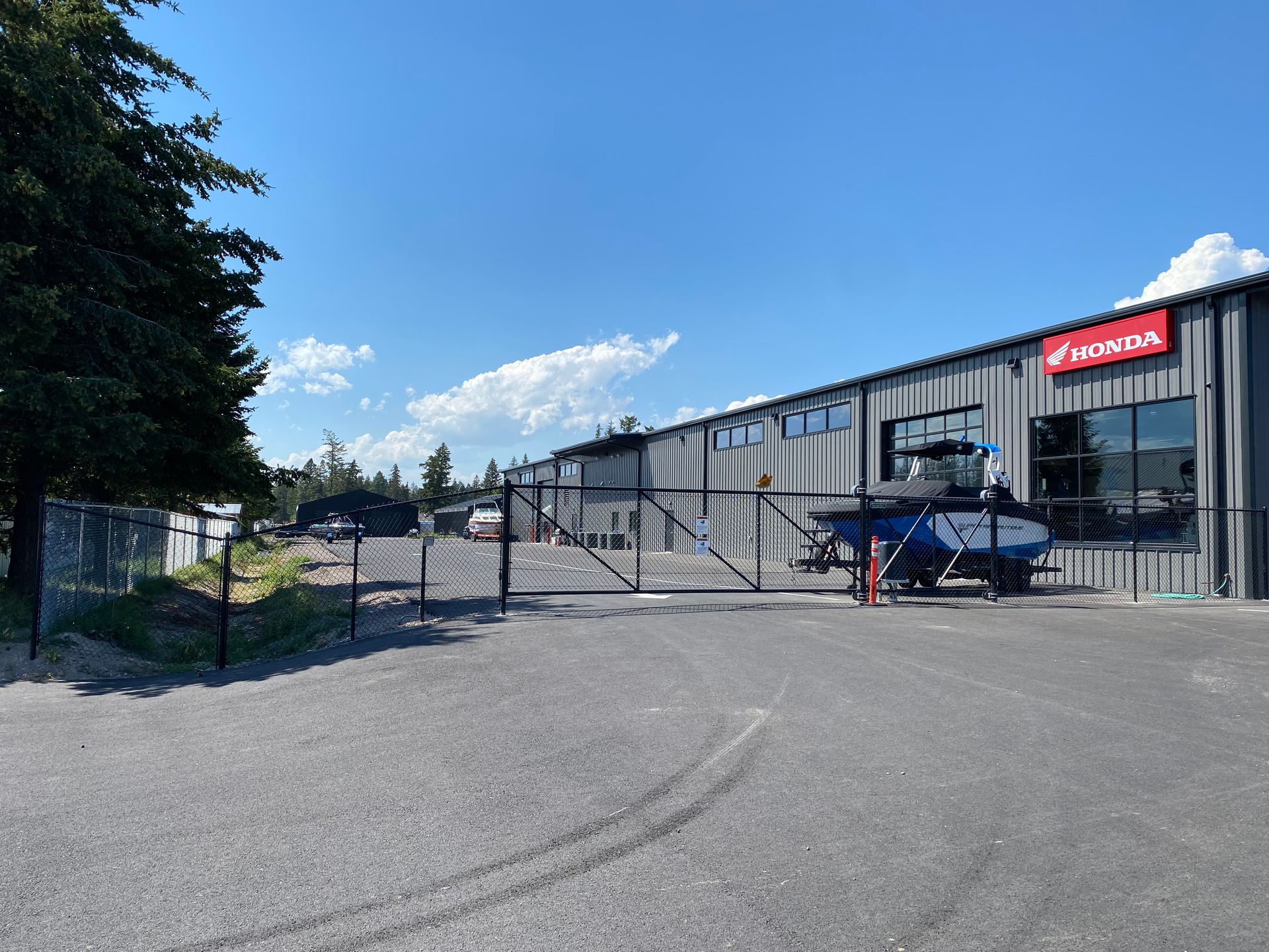 A large building with a fence and a helicopter parked in front of it.