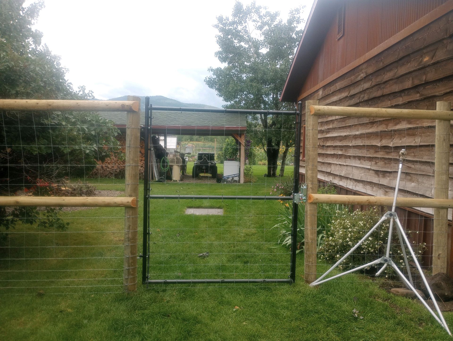 A fence with a gate in front of a wooden building.