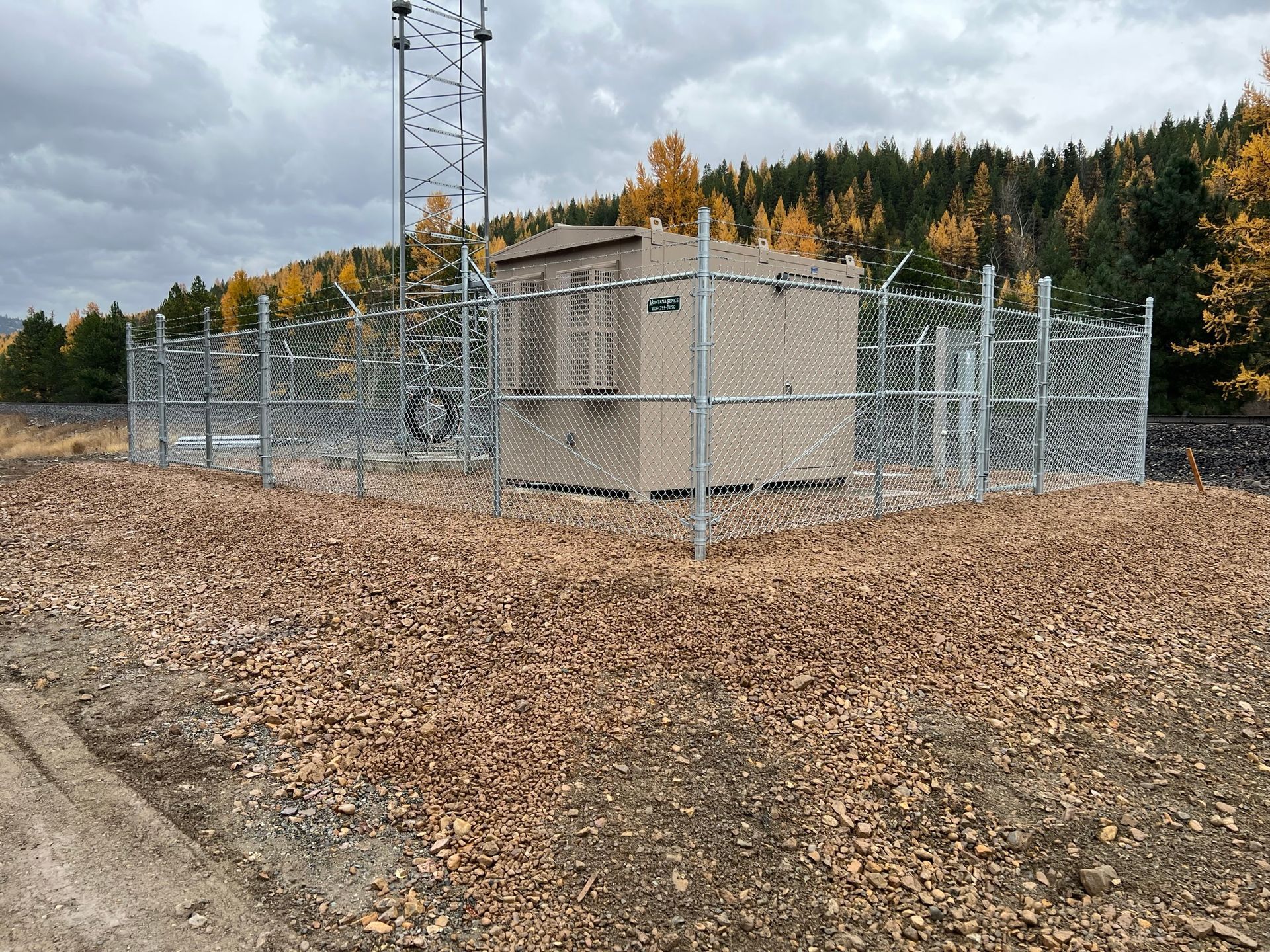 A fence around a building with a tower in the background