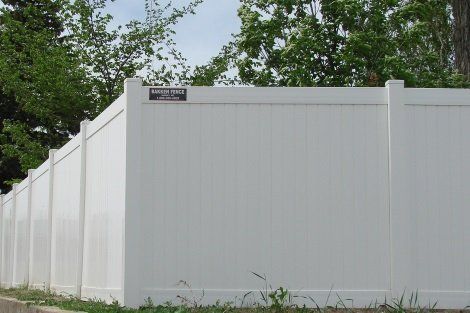 A white fence with a sign on it that says safety first