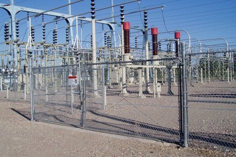 A fence surrounds a very large electrical substation