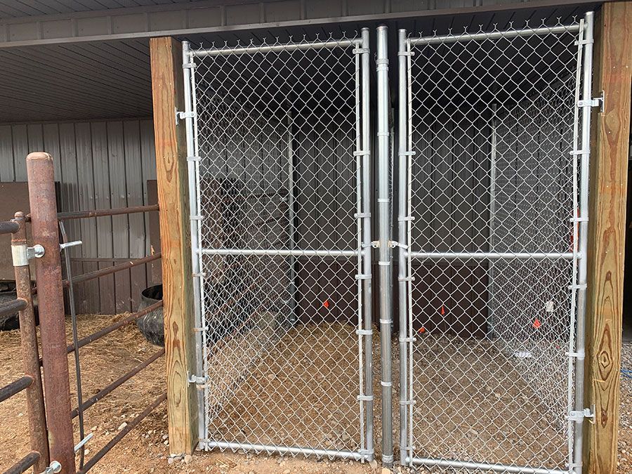 A chain link fence with a wooden post behind it
