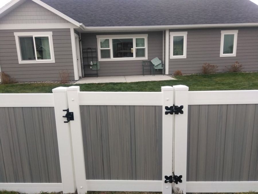 A gray house with a white fence in front of it