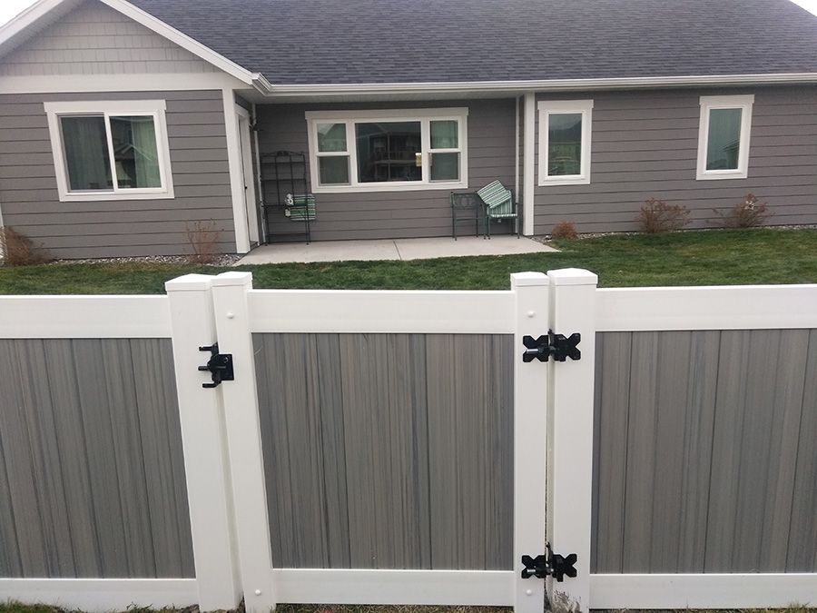 A gray house with a white fence in front of it