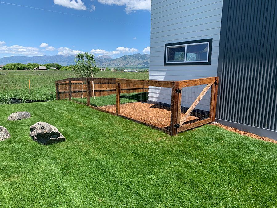 There is a wooden fence in the backyard of a house.