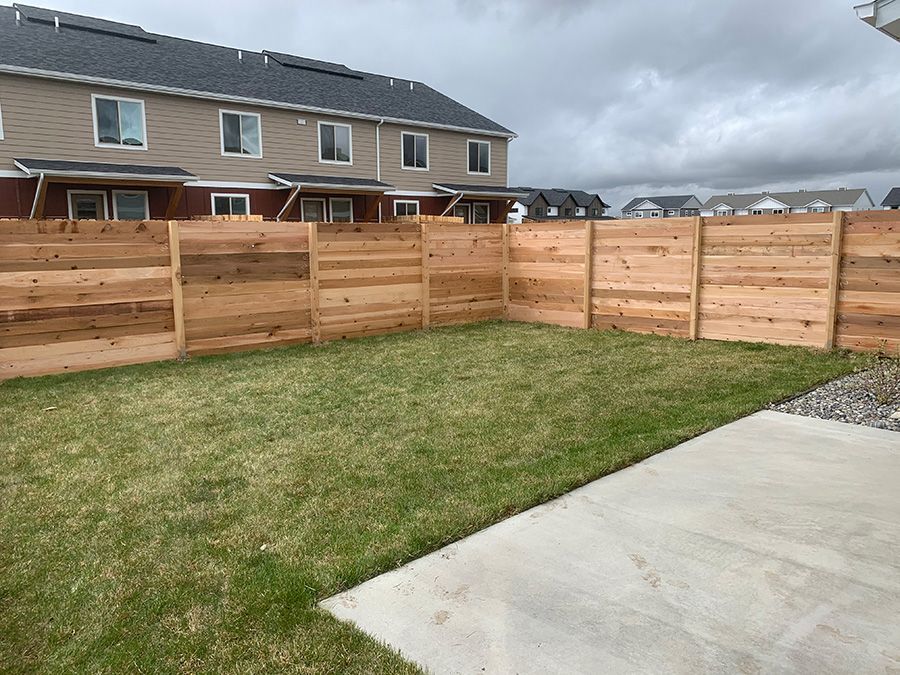There is a wooden fence in the backyard of a house.