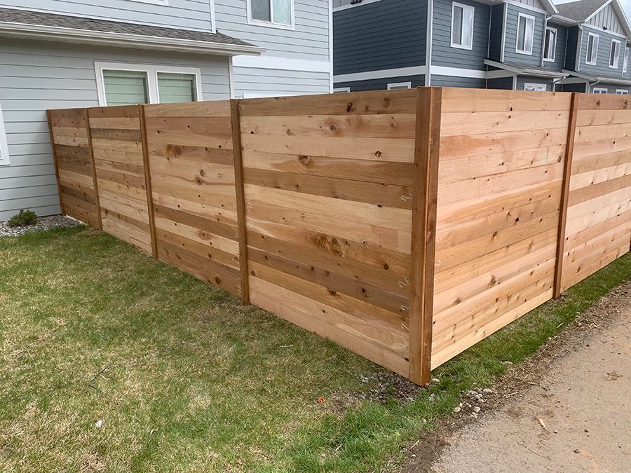 A wooden fence is sitting in front of a house.