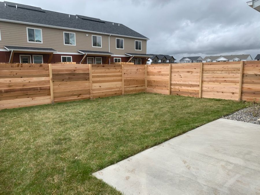 There is a wooden fence in the backyard of a house.