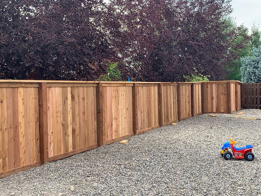 A wooden fence with a toy motorcycle in front of it.