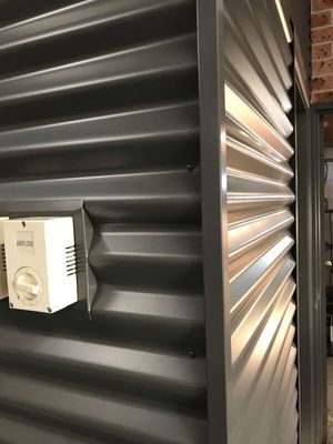 Gray Corrugated Metal Wall With a White Electrical Box — R&M Sheetmetal Nowra Metal Roofing in South Nowra, NSW