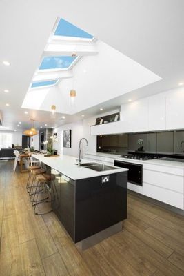 Modern Kitchen With Black Island, Skylights, and White Cabinets — R&M Sheetmetal Nowra Metal Roofing in South Nowra, NSW