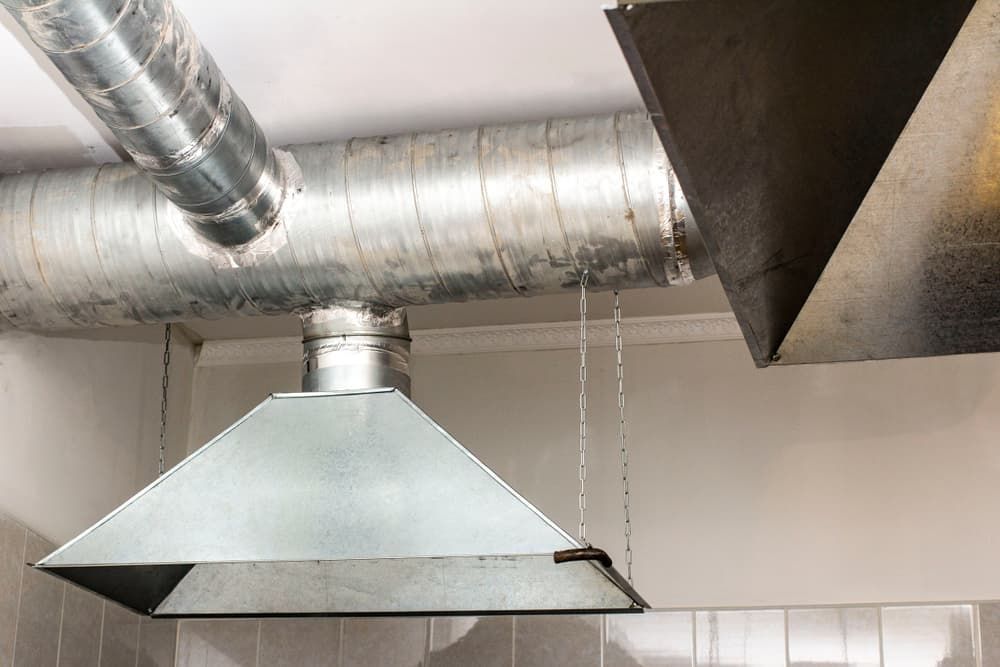 A Kitchen with A Hood and Pipes Hanging from The Ceiling — R&M Sheetmetal Nowra Metal Roofing in Ulladulla, NSW