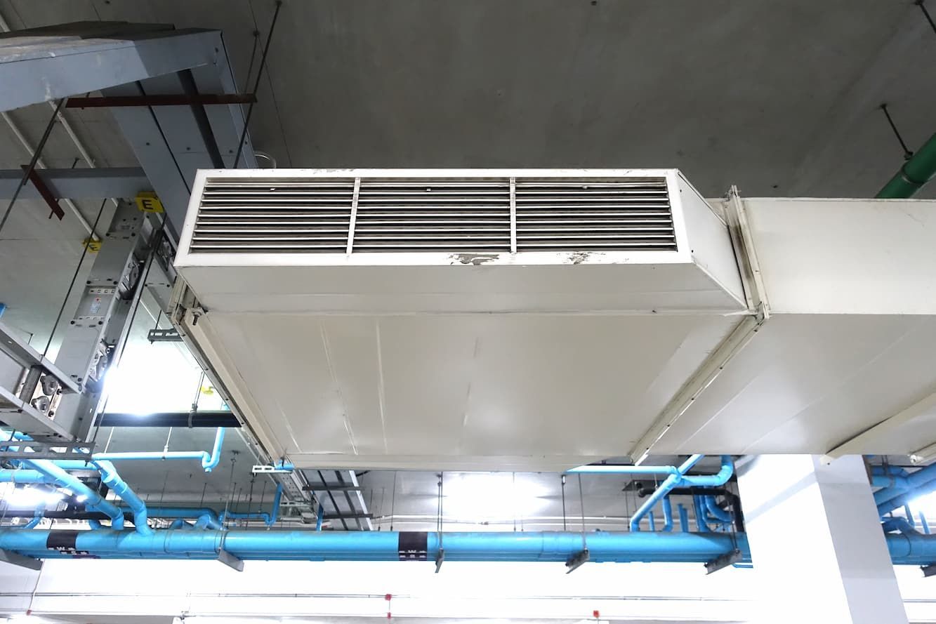 A White Air Duct Is Hanging from The Ceiling of A Building — R&M Sheetmetal Nowra Metal Roofing in Sussex, NSW