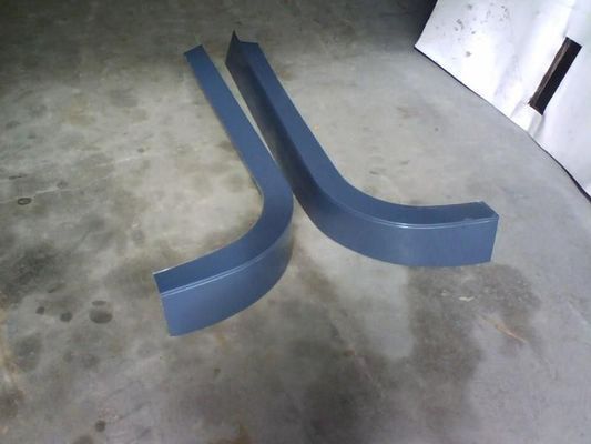 Two Bent, Gray Plastic Car Side Skirts Resting on a Concrete Floor — R&M Sheetmetal Nowra Metal Roofing in South Nowra, NSW