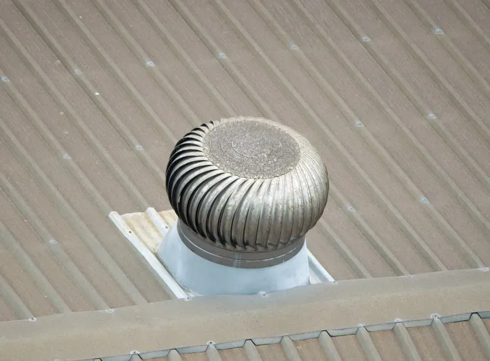 A rooftop wind turbine on a corrugated metal roof, gray and silver in color. — R&M Sheetmetal Nowra Metal Roofing in South Nowra, NSW