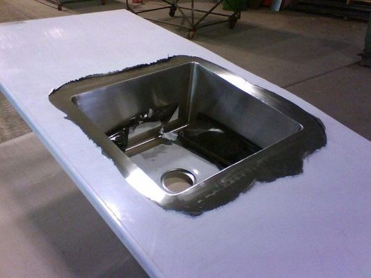 Stainless Steel Sink Inset Into a White Countertop, Showing Raw Edges — R&M Sheetmetal Nowra Metal Roofing in South Nowra, NSW