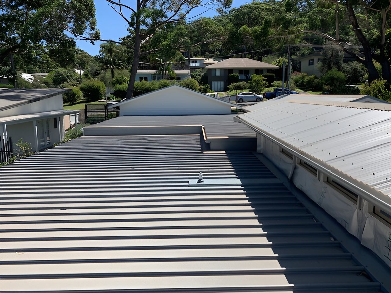 Gray metal roofs with a view of buildings and trees. — R&M Sheetmetal Nowra Metal Roofing in Kangaroo Valley, NSW