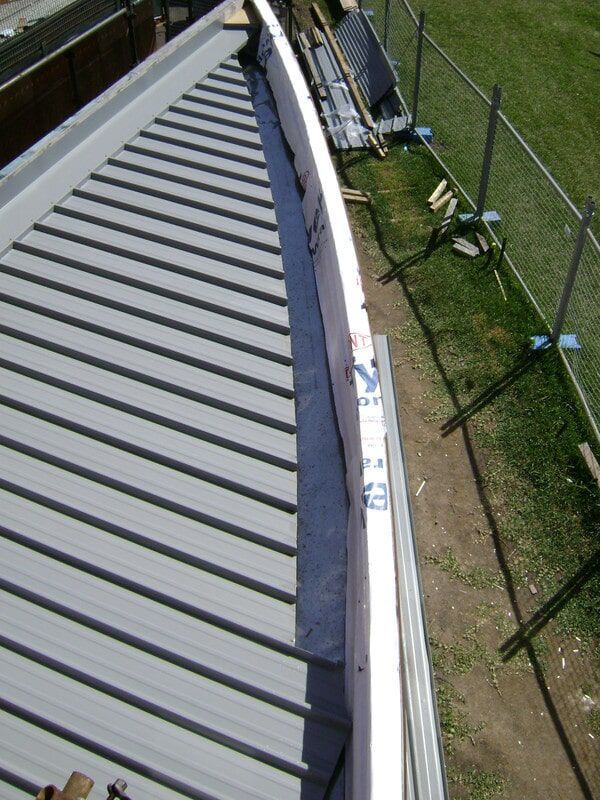An Aerial View of A Roof with A Fence in The Background — R&M Sheetmetal Nowra Metal Roofing in South Nowra, NSW