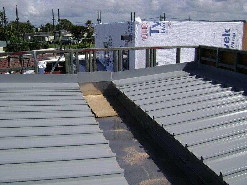 A Gray Metal Roof with A Roofing Material — R&M Sheetmetal Nowra Metal Roofing in South Nowra, NSW