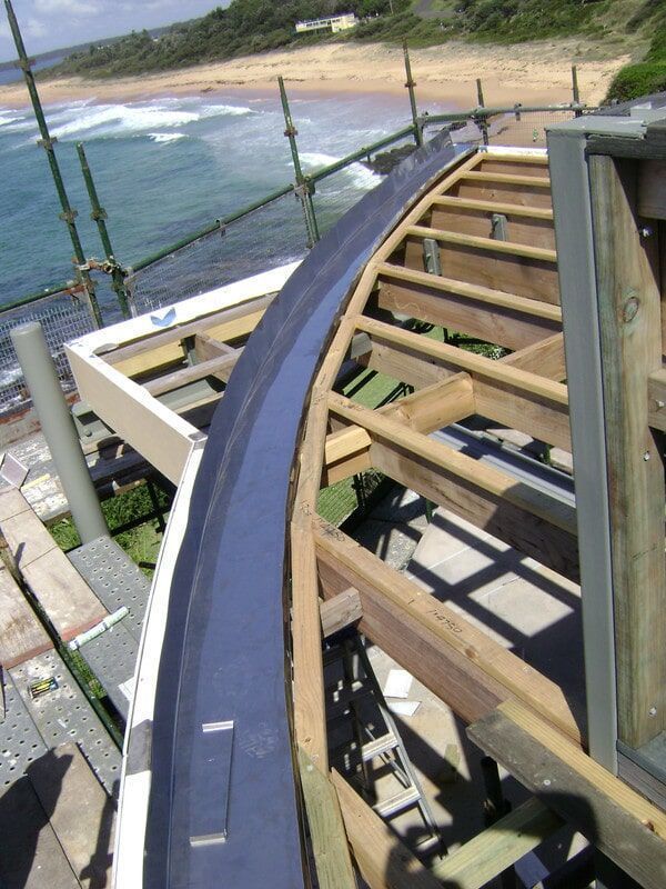 A Wooden Structure Is Being Built Near the Ocean — R&M Sheetmetal Nowra Metal Roofing in South Nowra, NSW