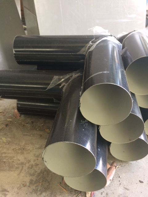 Black metal pipe fittings stacked on a light-colored surface. — R&M Sheetmetal Nowra Metal Roofing in South Nowra, NSW