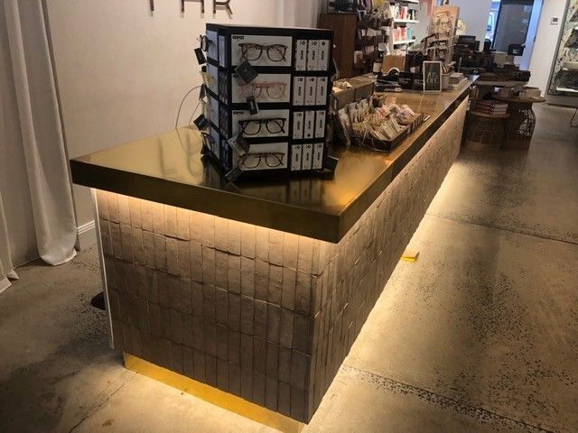A long counter in a store with a stack of boxes on it and lights — R&M Sheetmetal Nowra Metal Roofing in Culburra, NSW