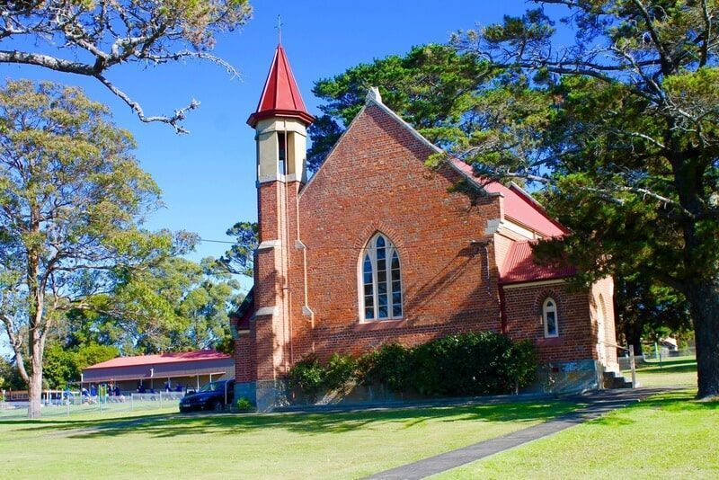 A Small Brick Church with A Red Roof and Steeple — R&M Sheetmetal Nowra Metal Roofing in South Nowra, NSW