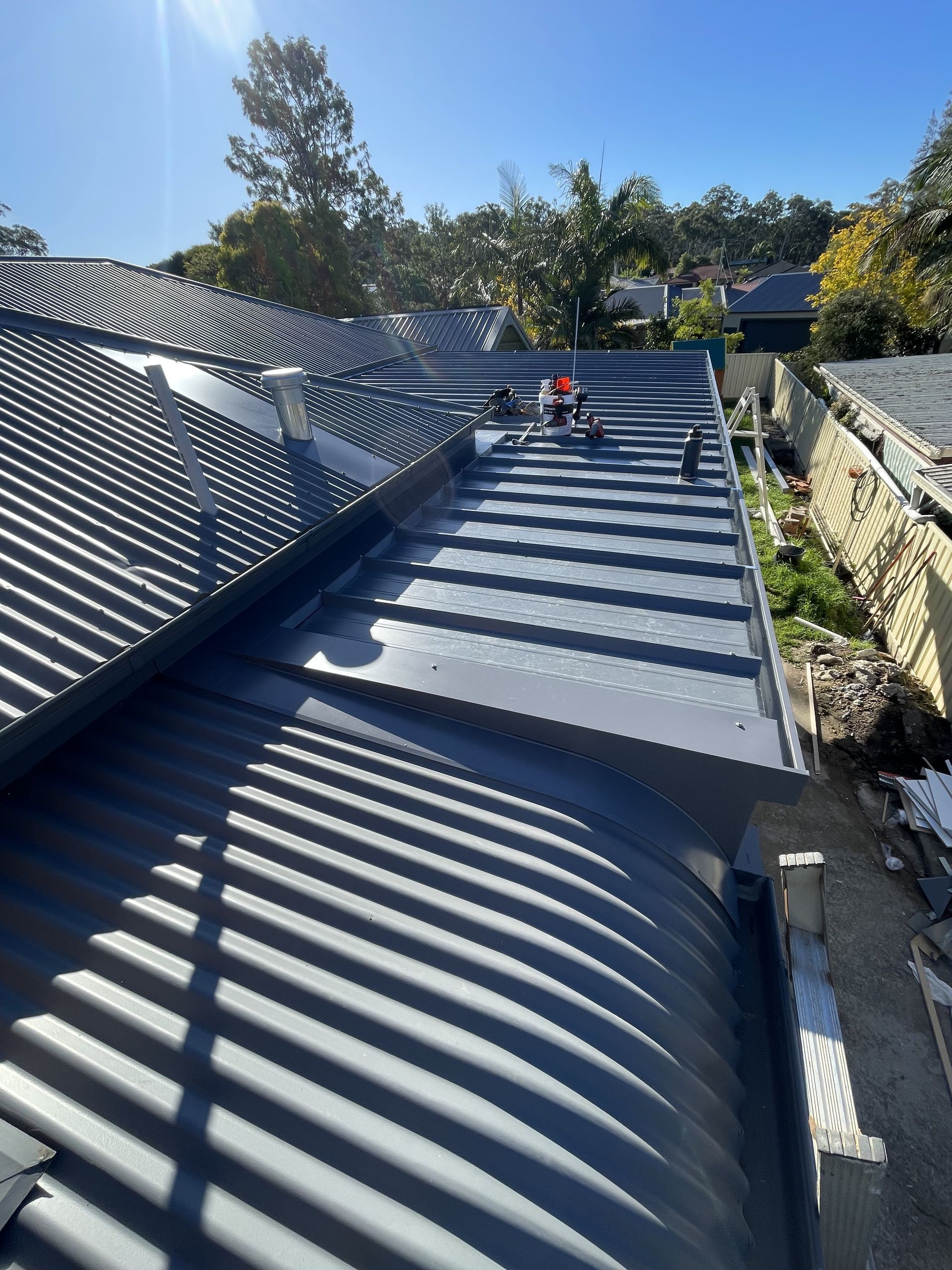 Workers on a Corrugated Metal Roof on a Sunny Day — R&M Sheetmetal Nowra Metal Roofing in South Nowra, NSW