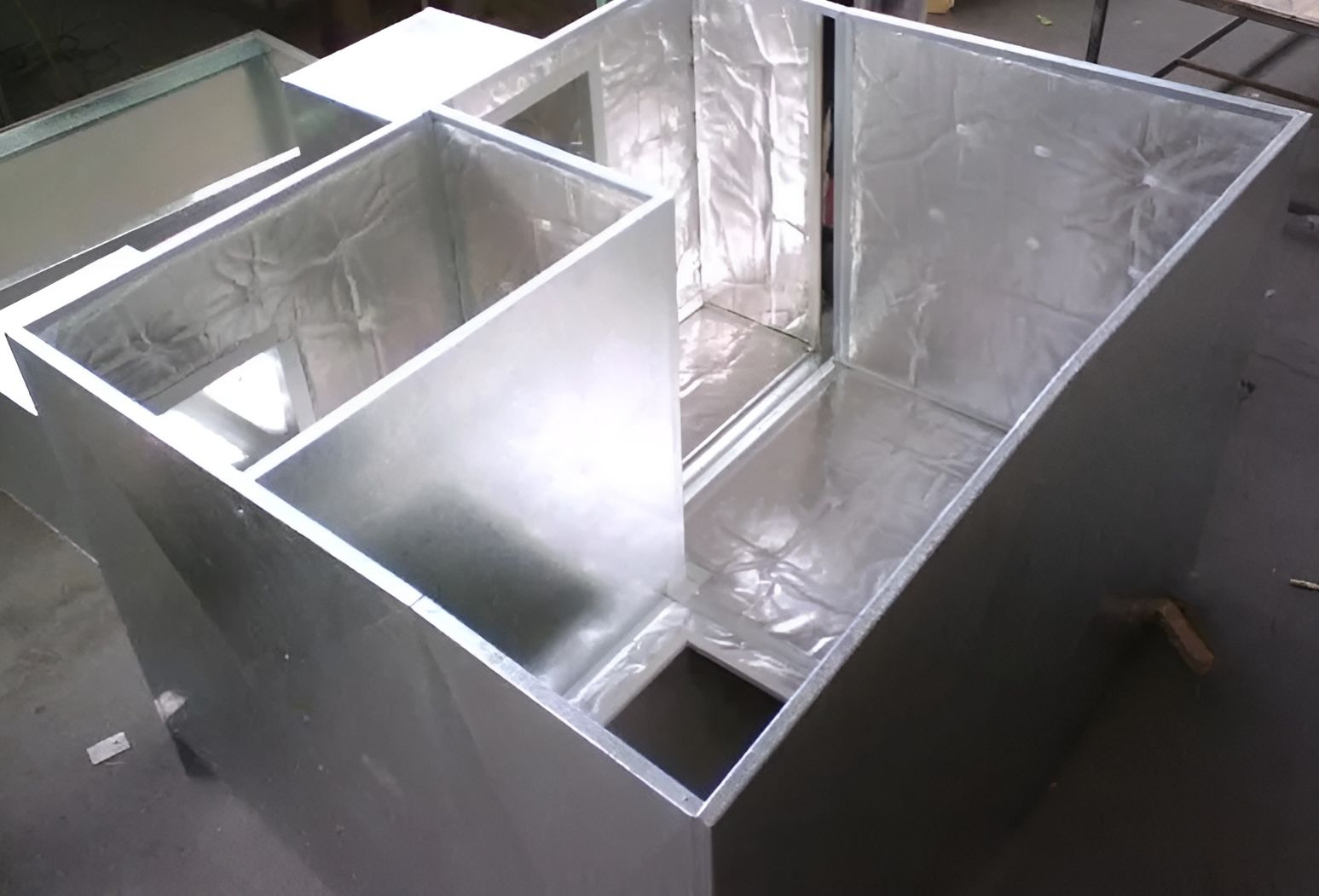 A group of metal boxes are sitting on top of each other on a table. — R&M Sheetmetal Nowra Metal Roofing in South Nowra, NSW