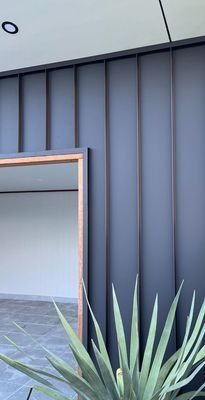A Plant Is Growing in Front of A Metal Wall Building — R&M Sheetmetal Nowra Metal Roofing in South Nowra, NSW