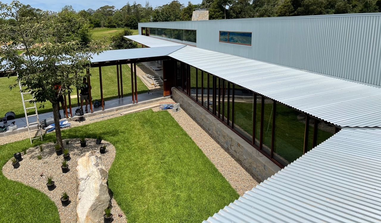 Modern Building with A Corrugated Metal Roof and Large Glass Windows — R&M Sheetmetal Nowra Metal Roofing in South Nowra, NSW