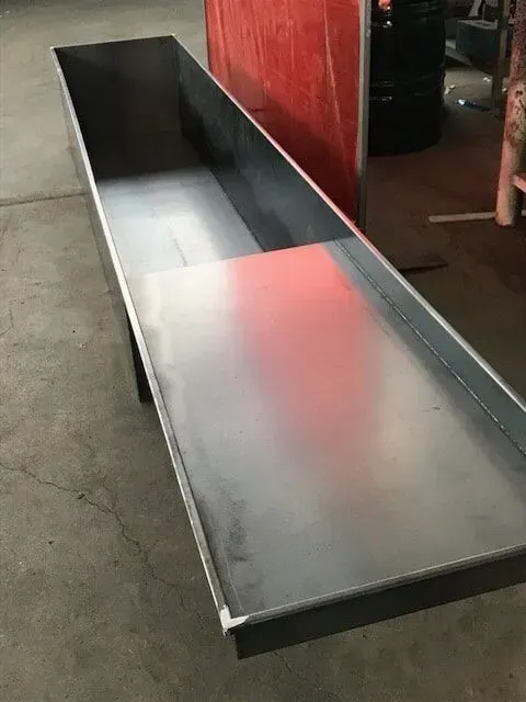 Long, rectangular metal trough with raised sides, likely for industrial use. — R&M Sheetmetal Nowra Metal Roofing in South Nowra, NSW