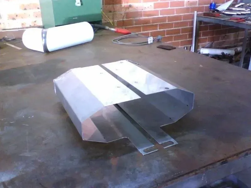 Aluminum metal fabrication on a metal table, with a water tank and tools in the background. — R&M Sheetmetal Nowra Metal Roofing in South Nowra, NSW
