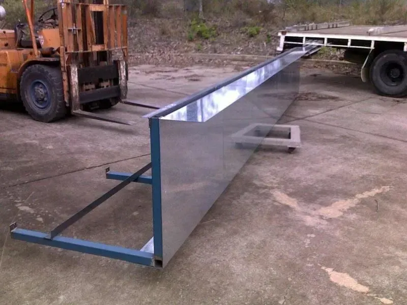 Metal rectangular structure supported by blue frame, being moved by forklift. Flatbed truck in background. — R&M Sheetmetal Nowra Metal Roofing in South Nowra, NSW