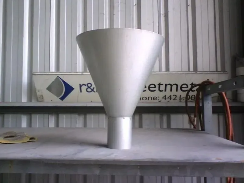 Silver metal funnel on a gray table, against a backdrop of a metal workshop. — R&M Sheetmetal Nowra Metal Roofing in South Nowra, NSW