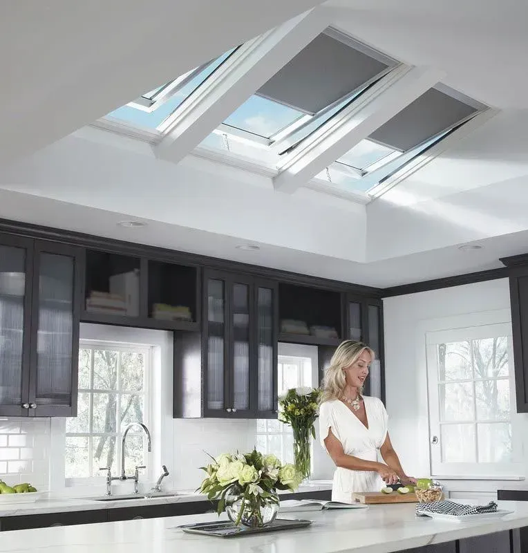 A Woman Is Preparing Food in A Kitchen with Skylights — R&M Sheetmetal Nowra Metal Roofing in South Nowra, NSW