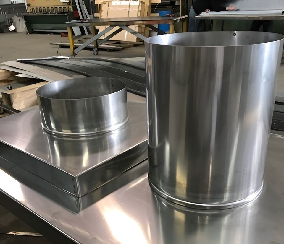 Metal cylinders and square sheets on a metal table, likely for manufacturing. — R&M Sheetmetal Nowra Metal Roofing in Nowra, NSW