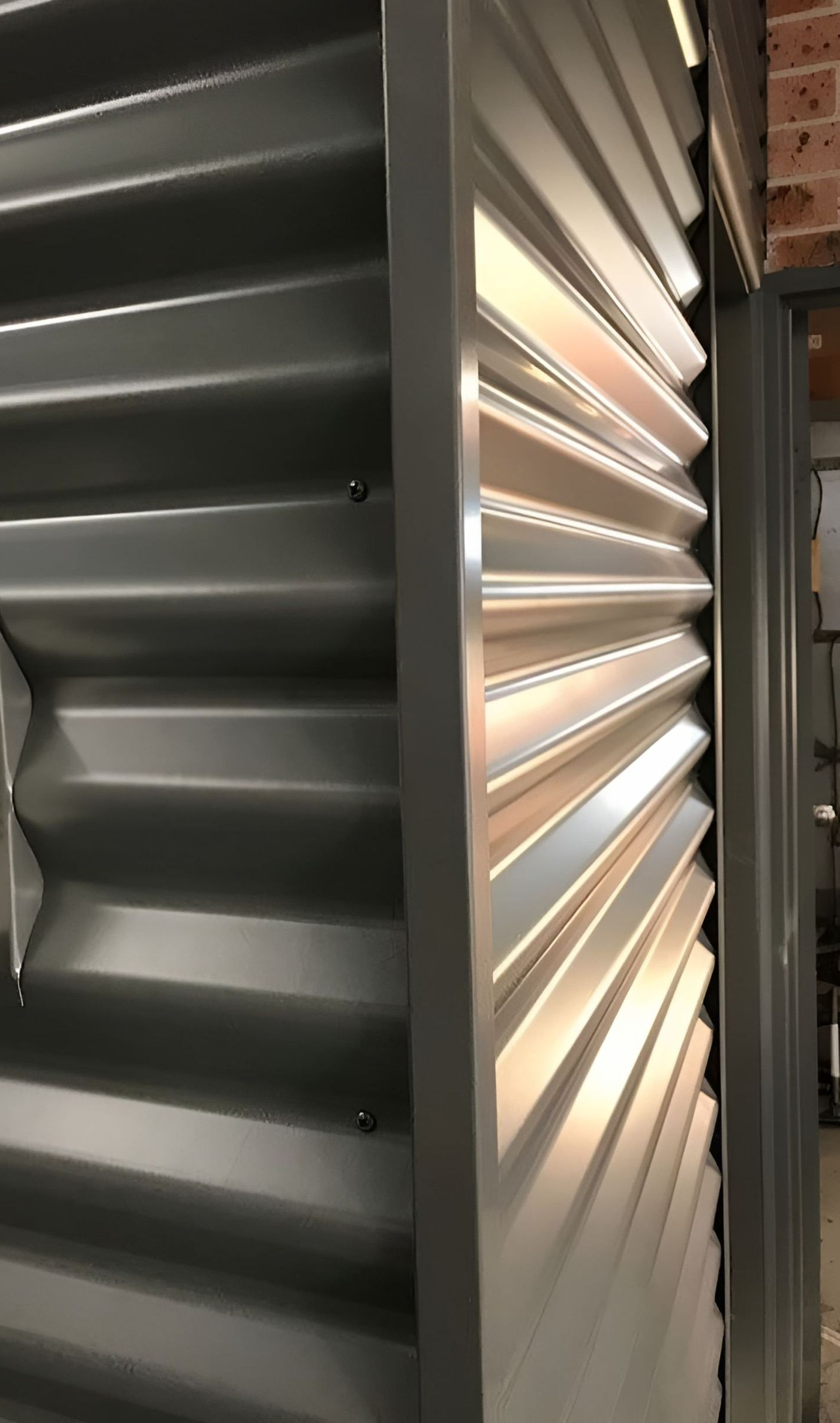 Gray corrugated metal wall panels with a frame, catching the light. — R&M Sheetmetal Nowra Metal Roofing in South Nowra, NSW