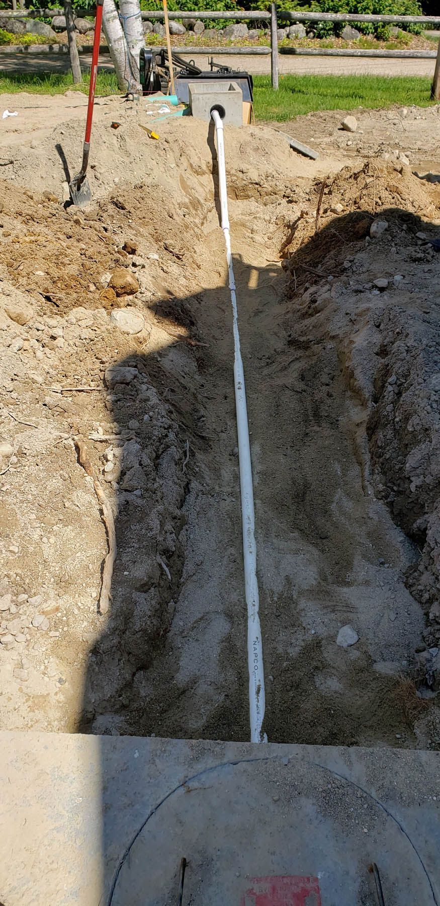 A trench in dirt with a measuring tape running down the middle.