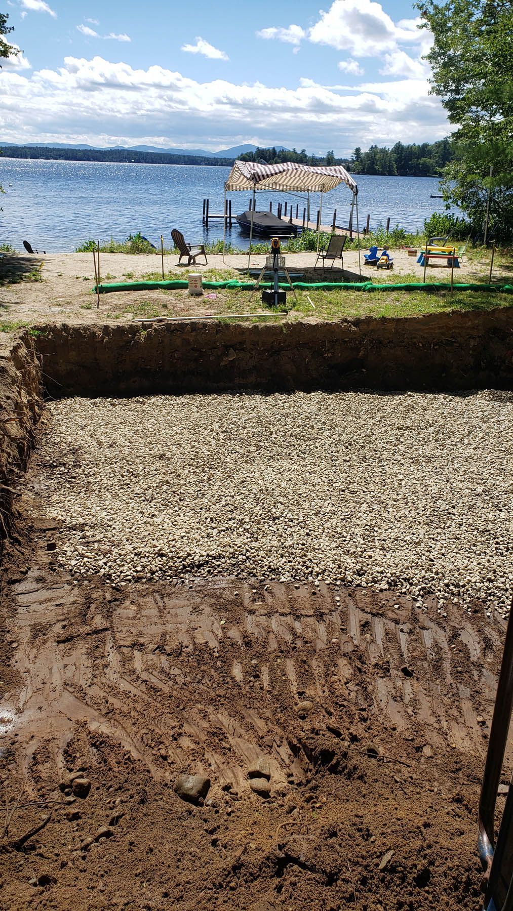 Excavated area filled with gravel; lake and dock in the background.