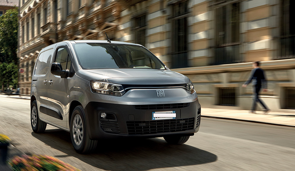 Una donna in abito lungo cammina davanti a un grande edificio.