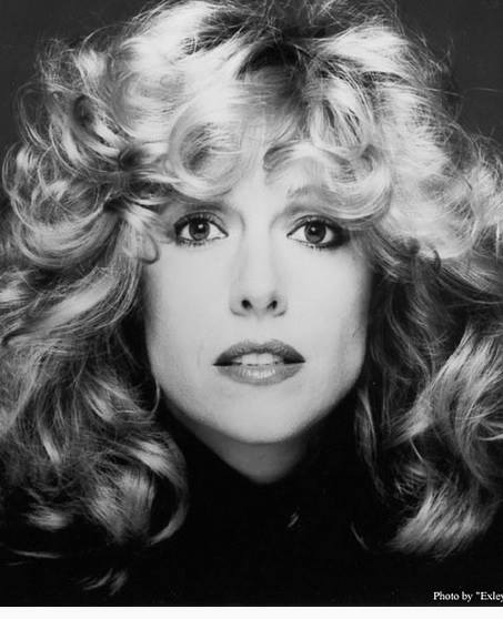 A black and white photo of a woman with curly hair