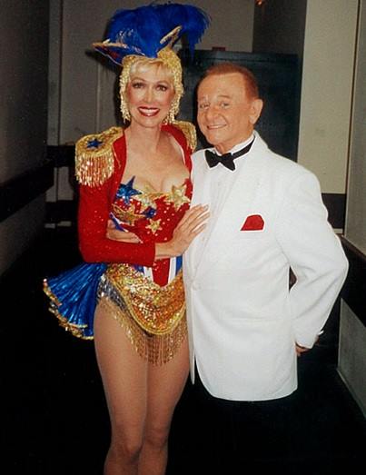 A woman in a wonder woman costume stands next to a man in a tuxedo