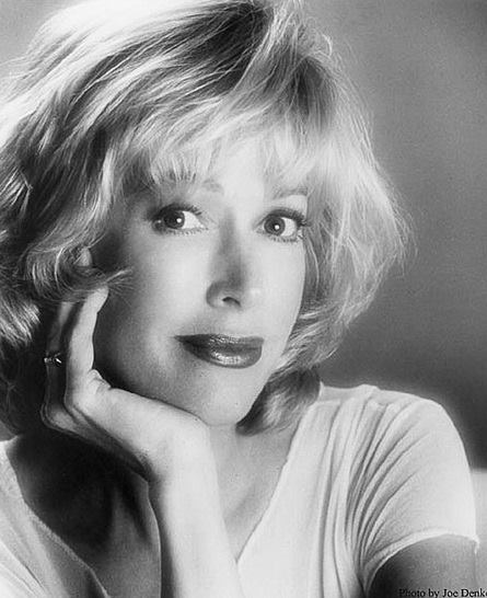 A black and white photo of a woman with her hand on her face.