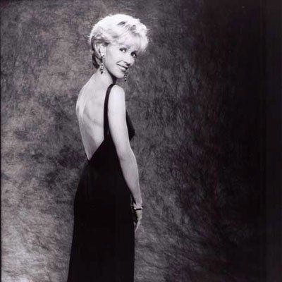 A black and white photo of a woman in a black dress.