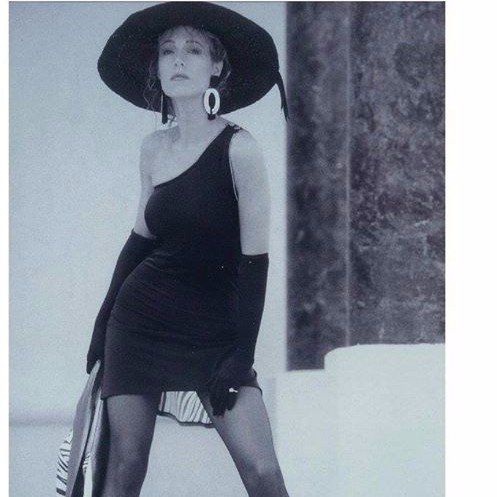 A black and white photo of a woman wearing a hat and gloves