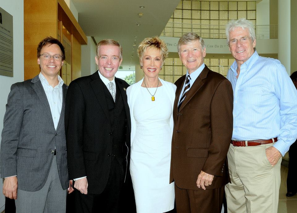 A group of men and a woman posing for a picture