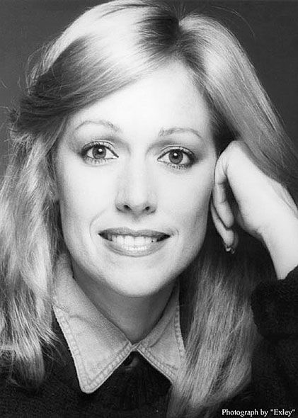 A black and white photo of a smiling woman