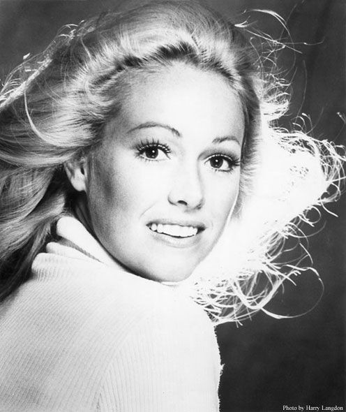 A black and white photo of a woman with her hair blowing in the wind