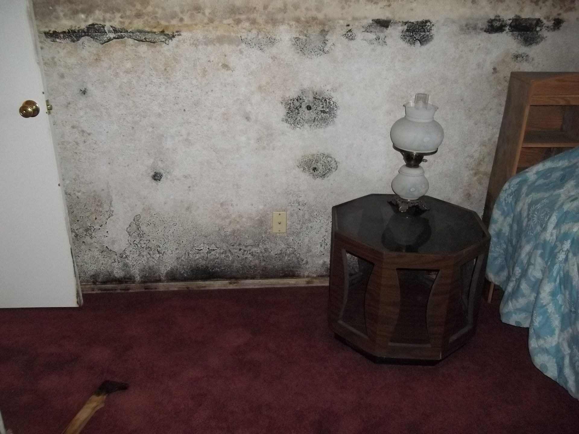 A bedroom with a lamp on a small table